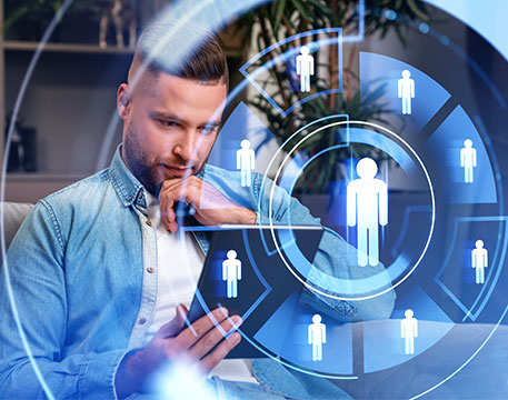 Ein Mann hält ein Tablet in der Hand und betrachtet eine digitale Darstellung von Nutzer-Symbolen, die in einem kreisförmigen Interface angeordnet sind und Konzepte wie Personalmanagement oder Talentverwaltung visualisieren.